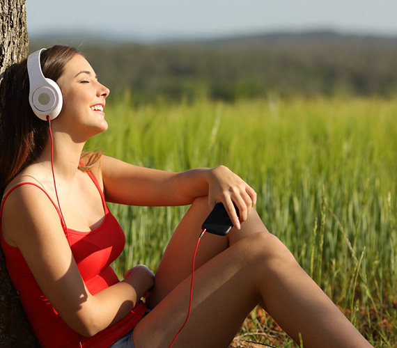 Frau sonnt sich und hört Musik