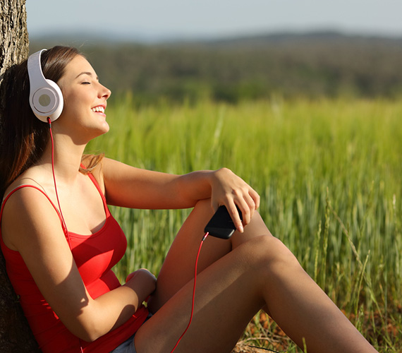 Frau sonnt sich und hört Musik